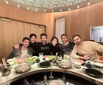 Cena de shabu-shabu alrededor de una mesa redonda