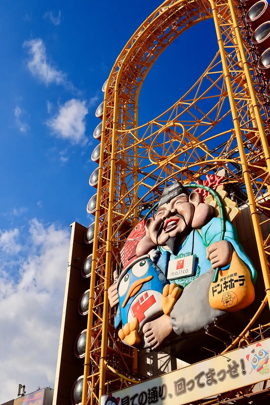Noria amarilla y figura gigante sobre la tienda Don Quijote de Dotonbori, en Osaka