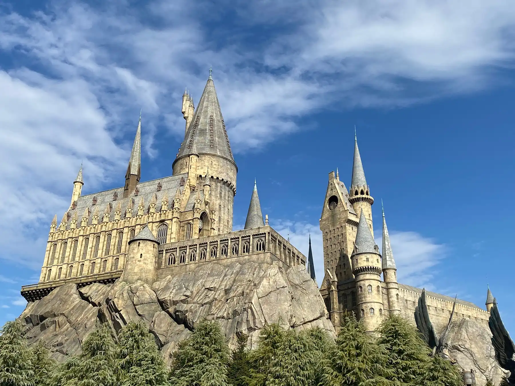 El castillo de Hogwarts sobre una gran roca, bajo un cielo azul