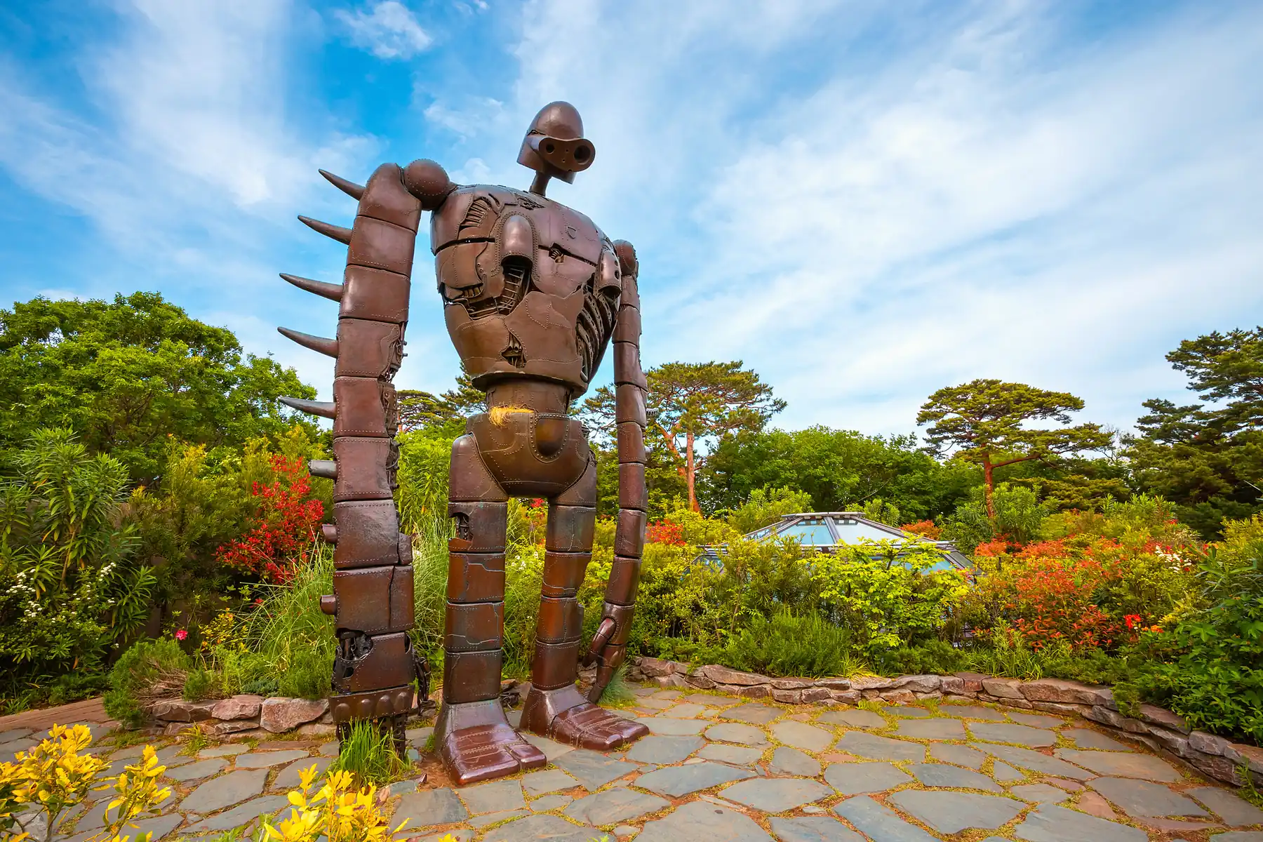 Estatua del robot gigante de El castillo en el cielo entre flores, en el jardín de la azotea del Museo Ghibli
