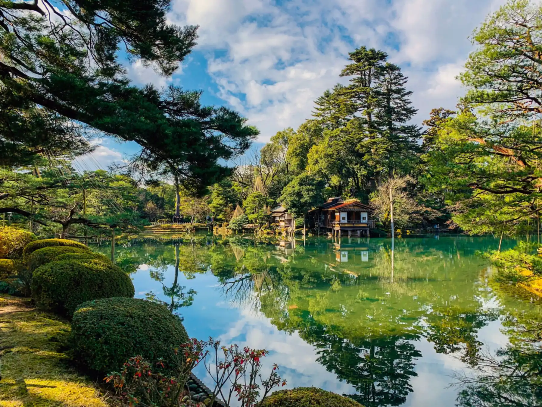 El estanque Kasumigaike del jardín Kenroku-en, con la casa de té Uchihashi-tei y los pinos reflejados en el agua, en Kanazawa